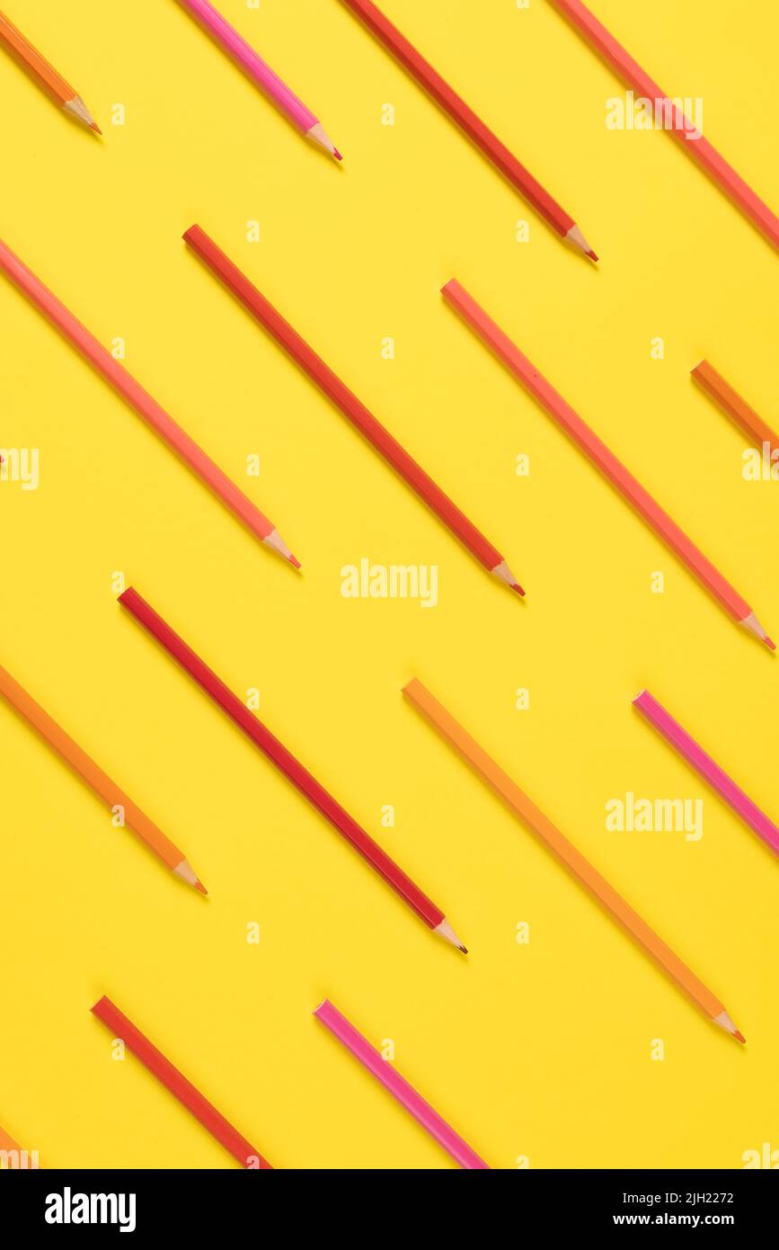 Imaginez des crayons de différentes nuances de rose sur fond jaune Banque D'Images