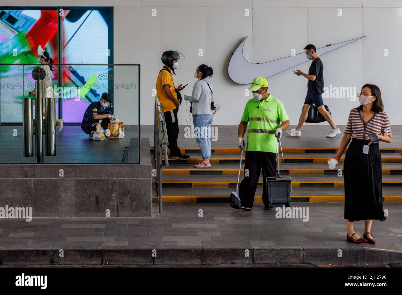 Les gens se trouvent à l'extérieur d'un centre commercial à Pékin, Chine, 13 juillet 2022. REUTERS/Thomas Peter Banque D'Images