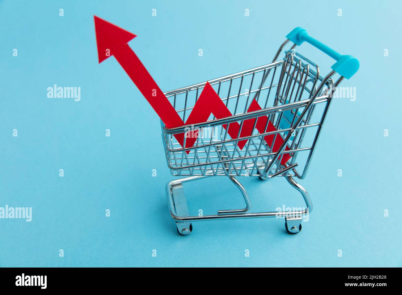 Augmentation du coût des achats. Chariot avec flèche rouge de gonflage Banque D'Images