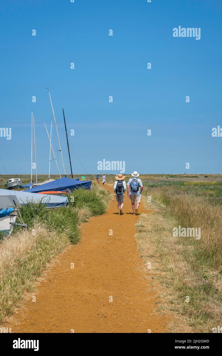 Couple marchant l'été, vue arrière d'un couple mature marchant sur le North Norfolk Coast Path lors d'une chaude journée d'été près de Blakeney, Norfolk, Angleterre, Royaume-Uni Banque D'Images