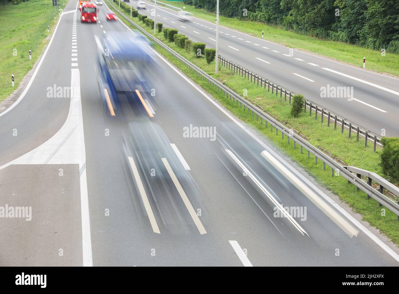 Transport par autoroute Interstate en été. Flou de mouvement des camions et des voitures qui passent sur une autoroute. Concept de transport et de voyage Banque D'Images