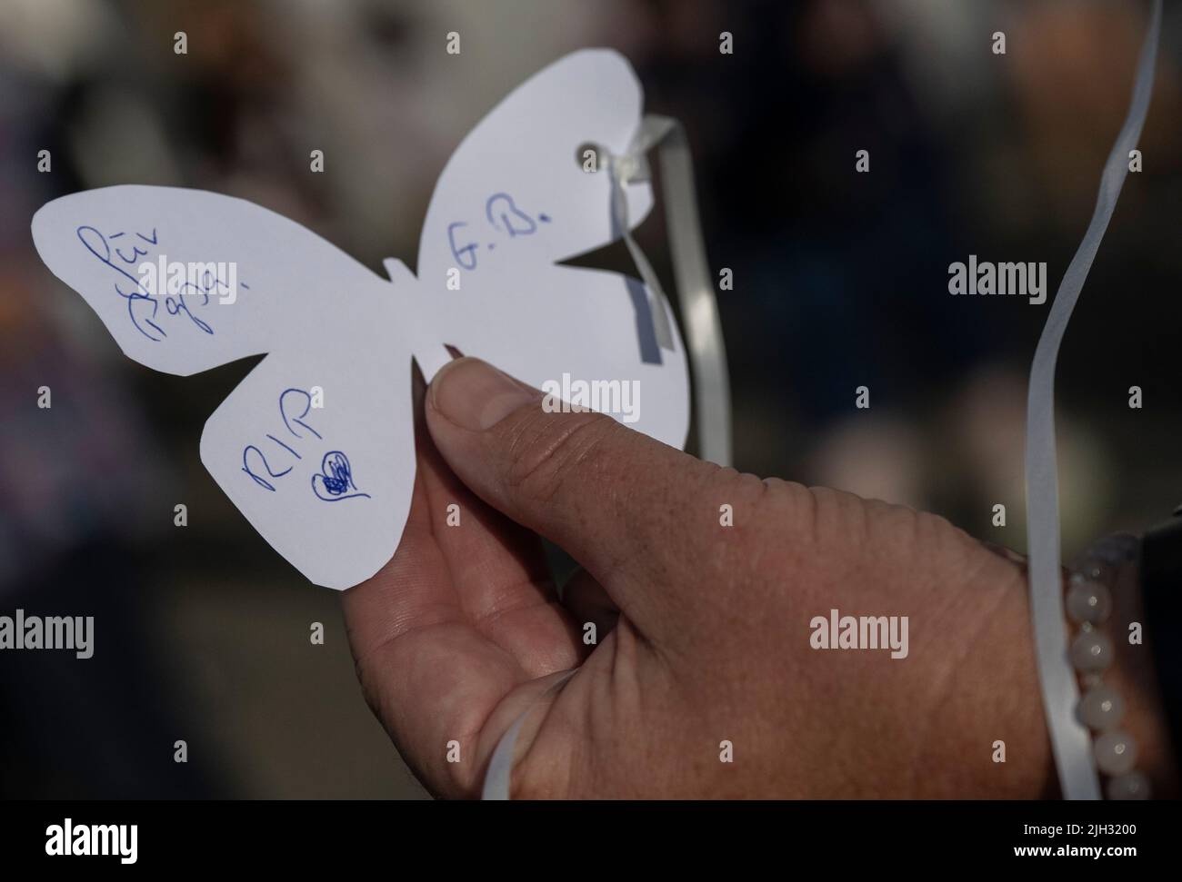 Schuld, Allemagne. 14th juillet 2022. 'Pour Papa. RIP' est écrit sur un papillon de papier blanc qu'une femme attachée à un ballon blanc devant l'église de Schuld pour le laisser monter dans l'air. Schuld avait été extrêmement endommagé par les eaux de crue. Crédit : Boris Roessler/dpa/Alay Live News Banque D'Images