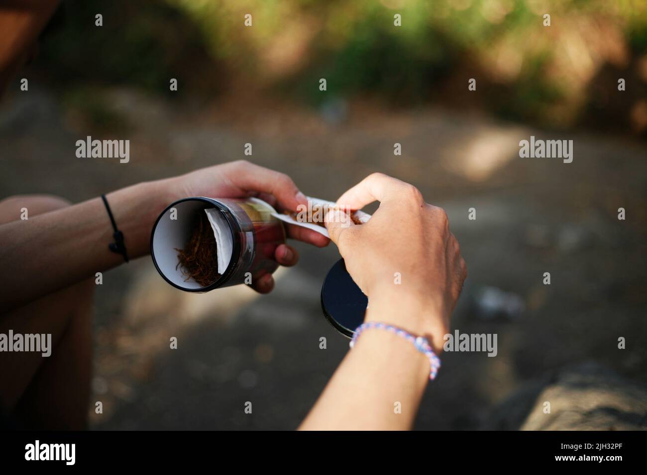 Gros plan des mains préparant un tabac pour fumer Banque D'Images