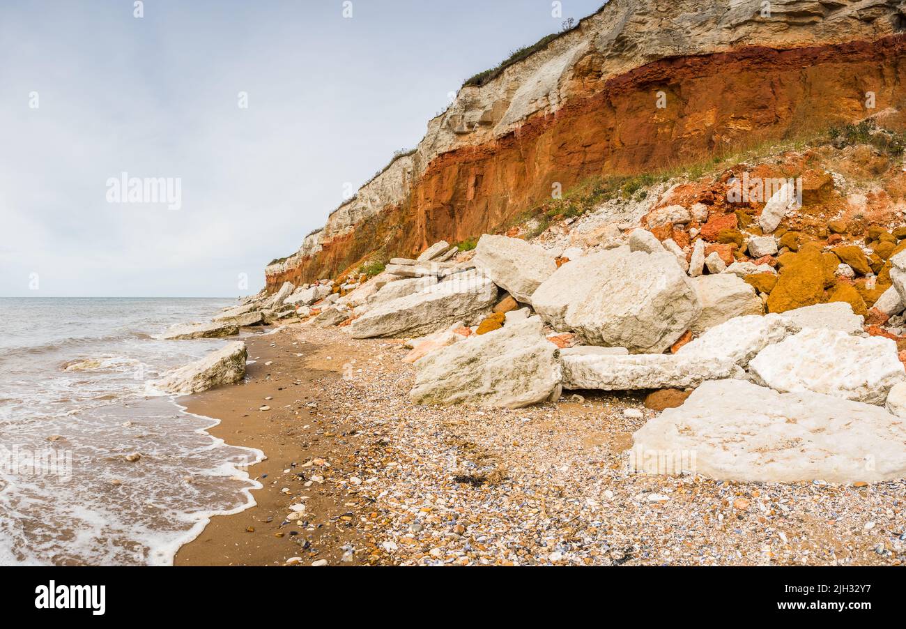 Un panorama à plusieurs images de la roche rouge et blanche caractéristique vue dans les escarpes sur les falaises de Hunstanton sur la côte nord de Norfolk. Banque D'Images