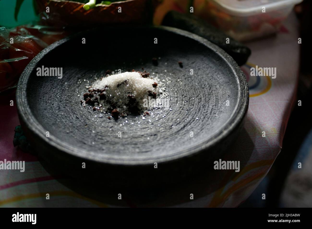 Fermez la pâte de crevettes, le sucre et le sel dans le mortier de pierre les ingrédients ou condiment de la nourriture de saveurs indonésiennes de sambal Banque D'Images