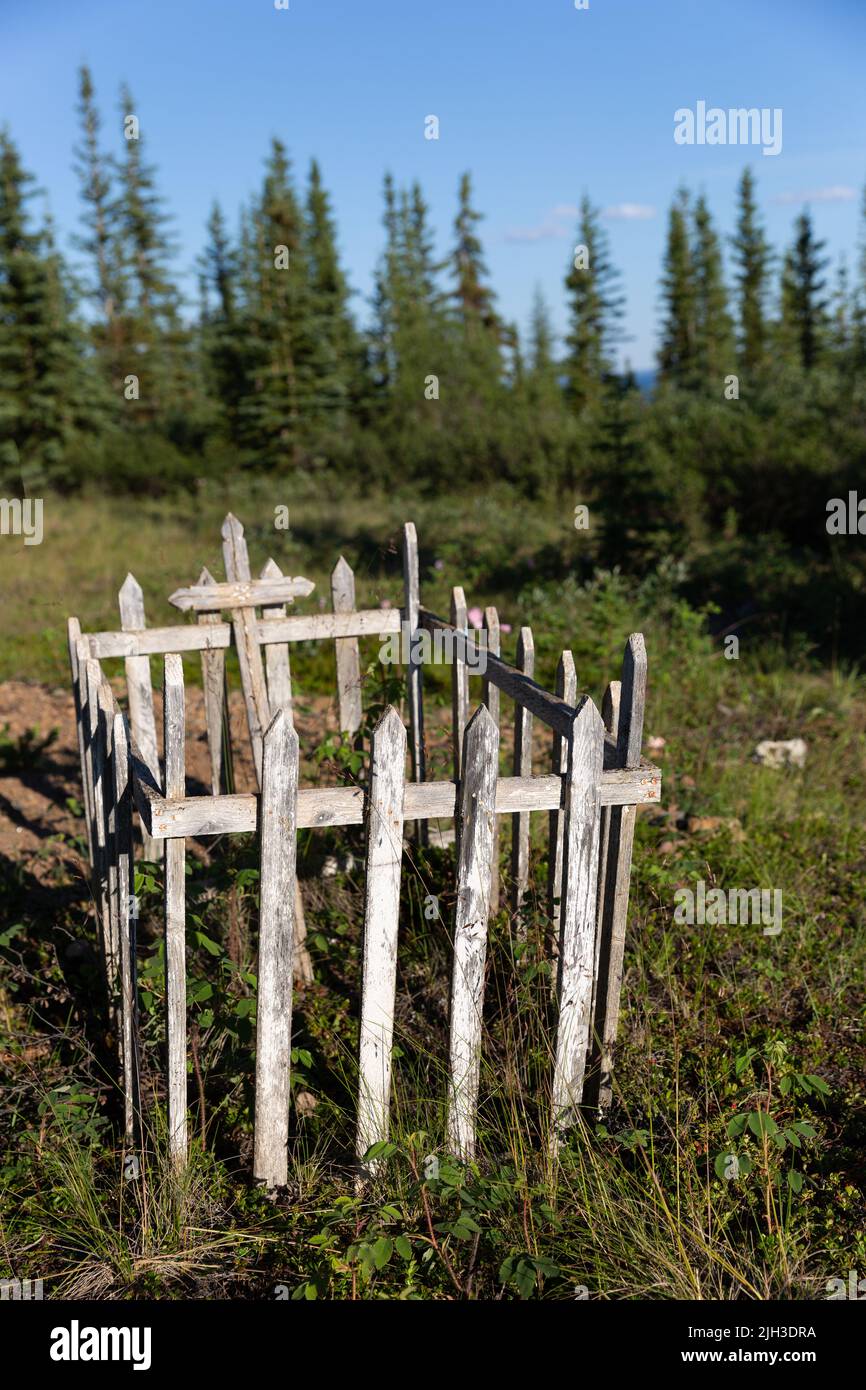 Une vieille tombe clôturée en bois dans un cimetière, dans la communauté autochtone du nord de Deline, Territoires du Nord-Ouest, Canada Banque D'Images