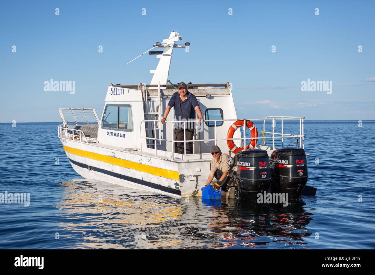 Des Dénés, en bateau, recueillent de l'eau potable fraîche du Grand lac Bear, à l'extérieur de la communauté autochtone de Deline, Territoires du Nord-Ouest, Canada. Banque D'Images