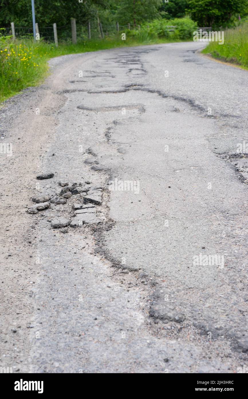 Surface de la route brisée et endommagée dans les Highlands d'Écosse, au Royaume-Uni. Banque D'Images