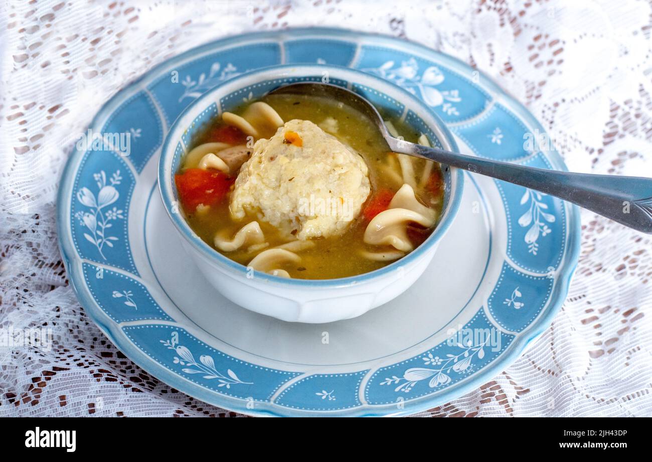 Un joli bol de soupe de nouilles de poulet, servi avec une grande boule de mazzo moelleuse et des morceaux de carottes et de poulet Banque D'Images