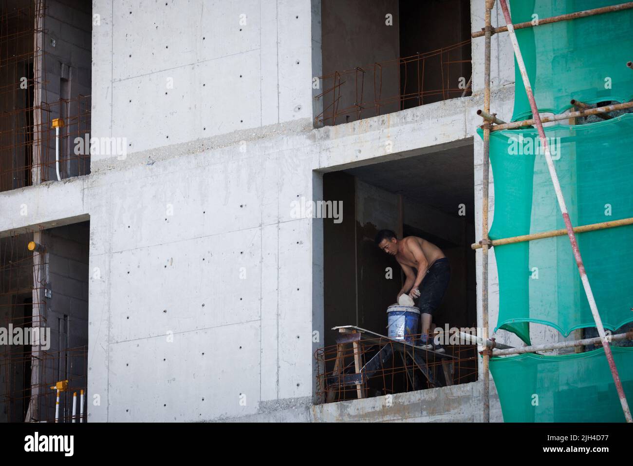 Un homme travaille sur un chantier de construction d'immeubles à Pékin, en Chine, au 15 juillet 2022. REUTERS/Thomas Peter Banque D'Images