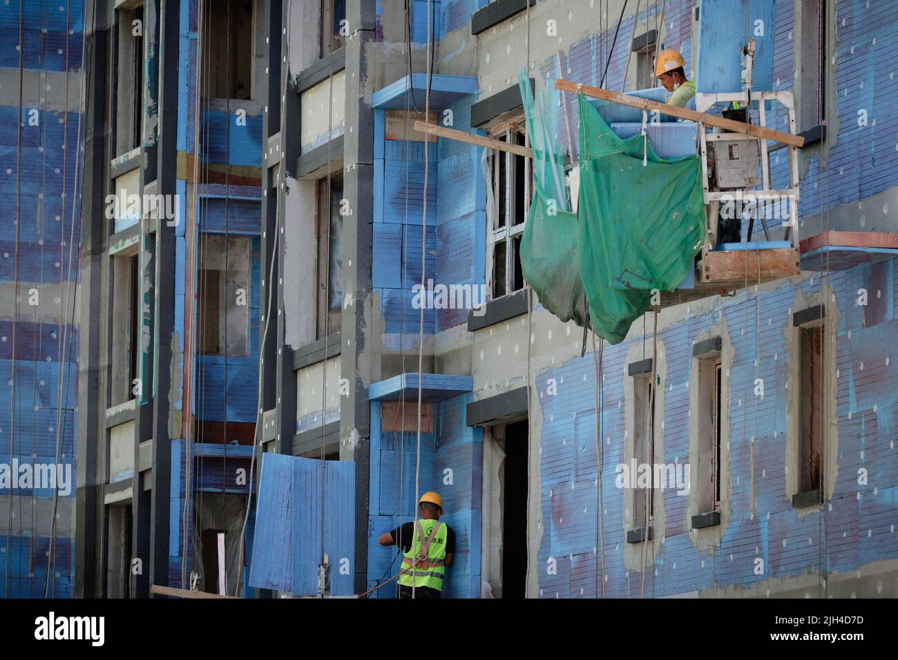 Des hommes travaillent dans un chantier de construction d'immeubles à Pékin, Chine, 15 juillet 2022. REUTERS/Thomas Peter Banque D'Images