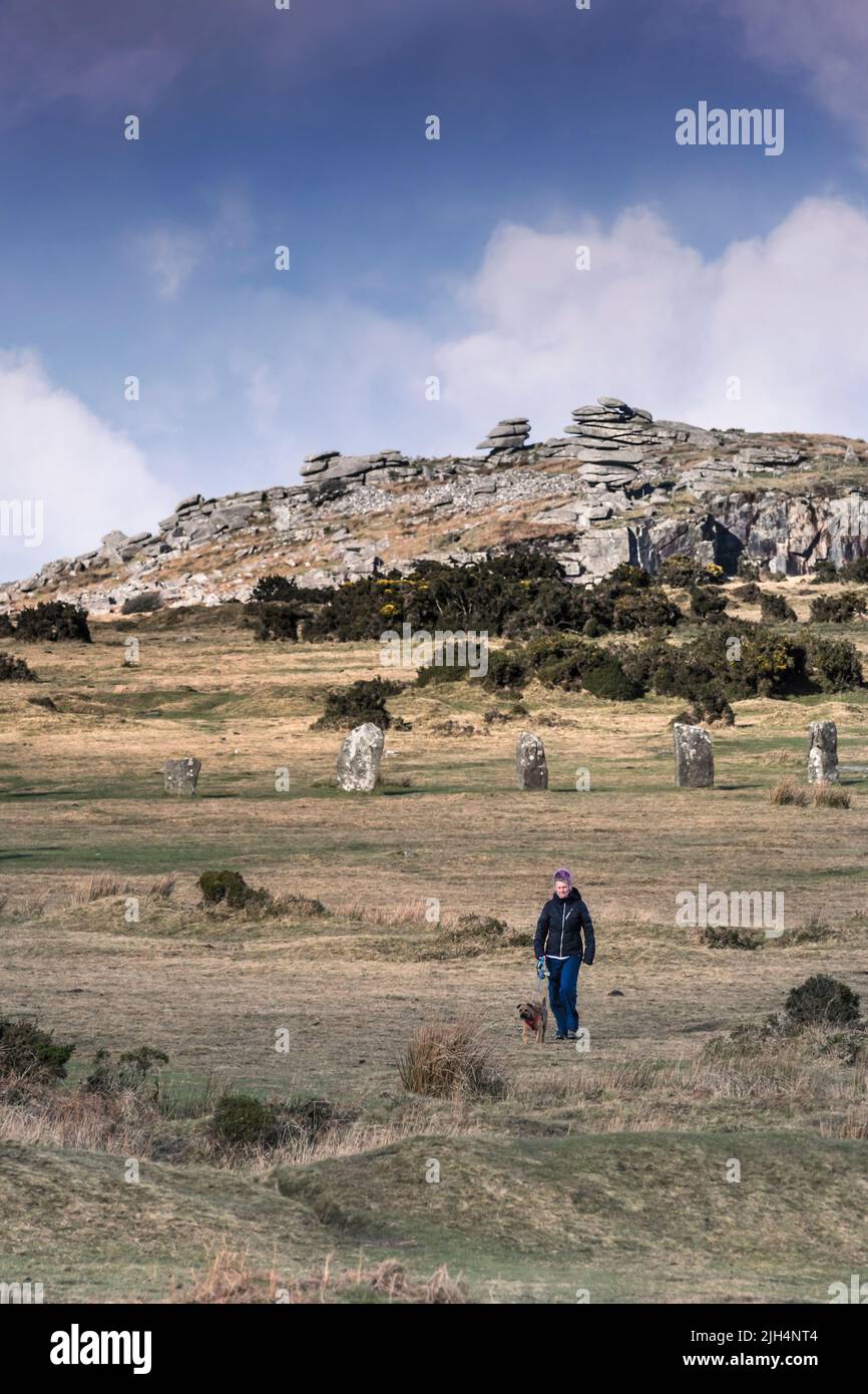 Une femme qui marche son chien avec le Néolithique, des pierres des Hurlers et la carrière de granit sauvage sur Stowes Hill sur Bodmin Moor en Cornouailles. Banque D'Images