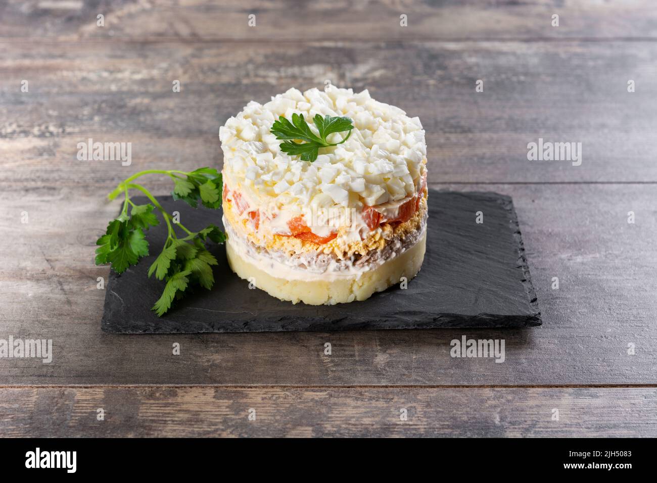 Salade russe traditionnelle Mimosa sur table en bois Banque D'Images