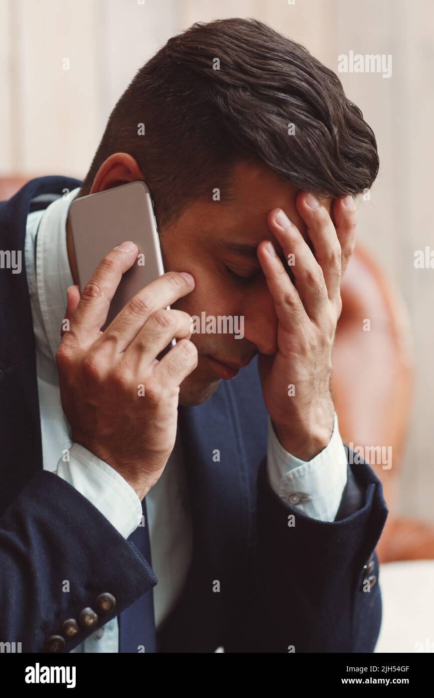 Homme recevant de mauvaises nouvelles au téléphone Banque D'Images