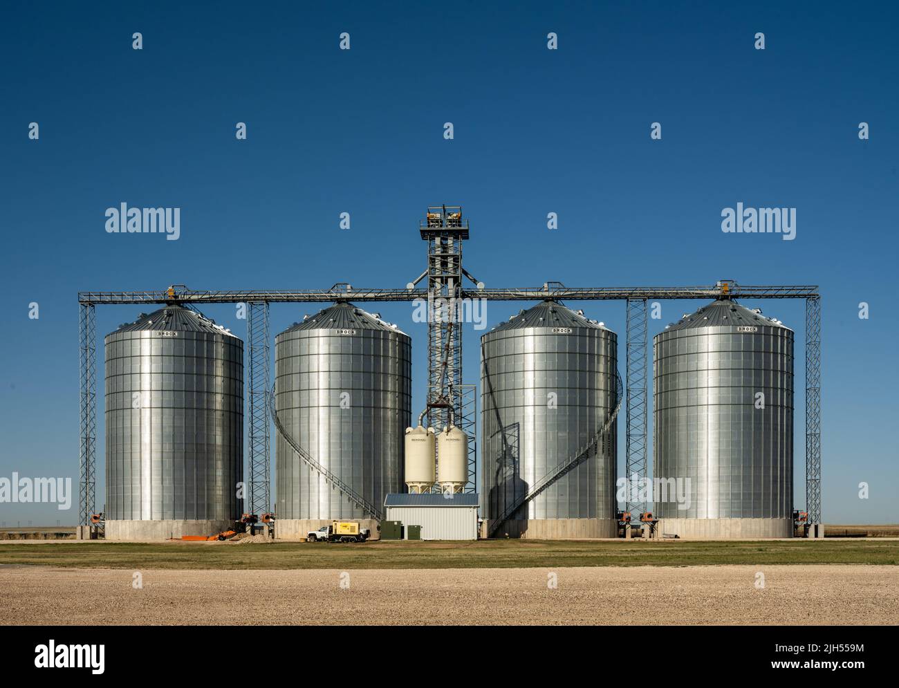 Quatre élévateurs de grain se font face au ciel bleu Banque D'Images