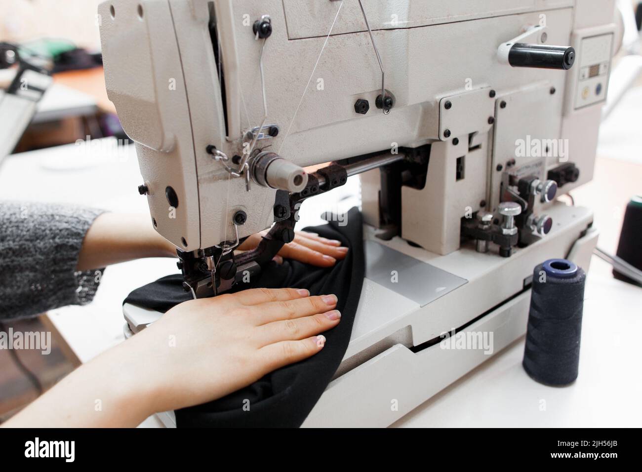 Femme couture de tissu foncé sur machine à coudre Banque D'Images