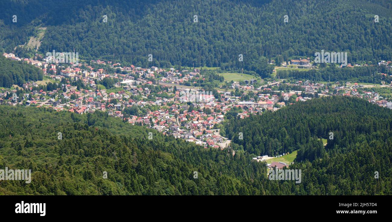 Panorama aérien du village de Busteni dans la vallée de Prahova, entouré par la forêt, une destination de plein air populaire en Roumanie. Banque D'Images