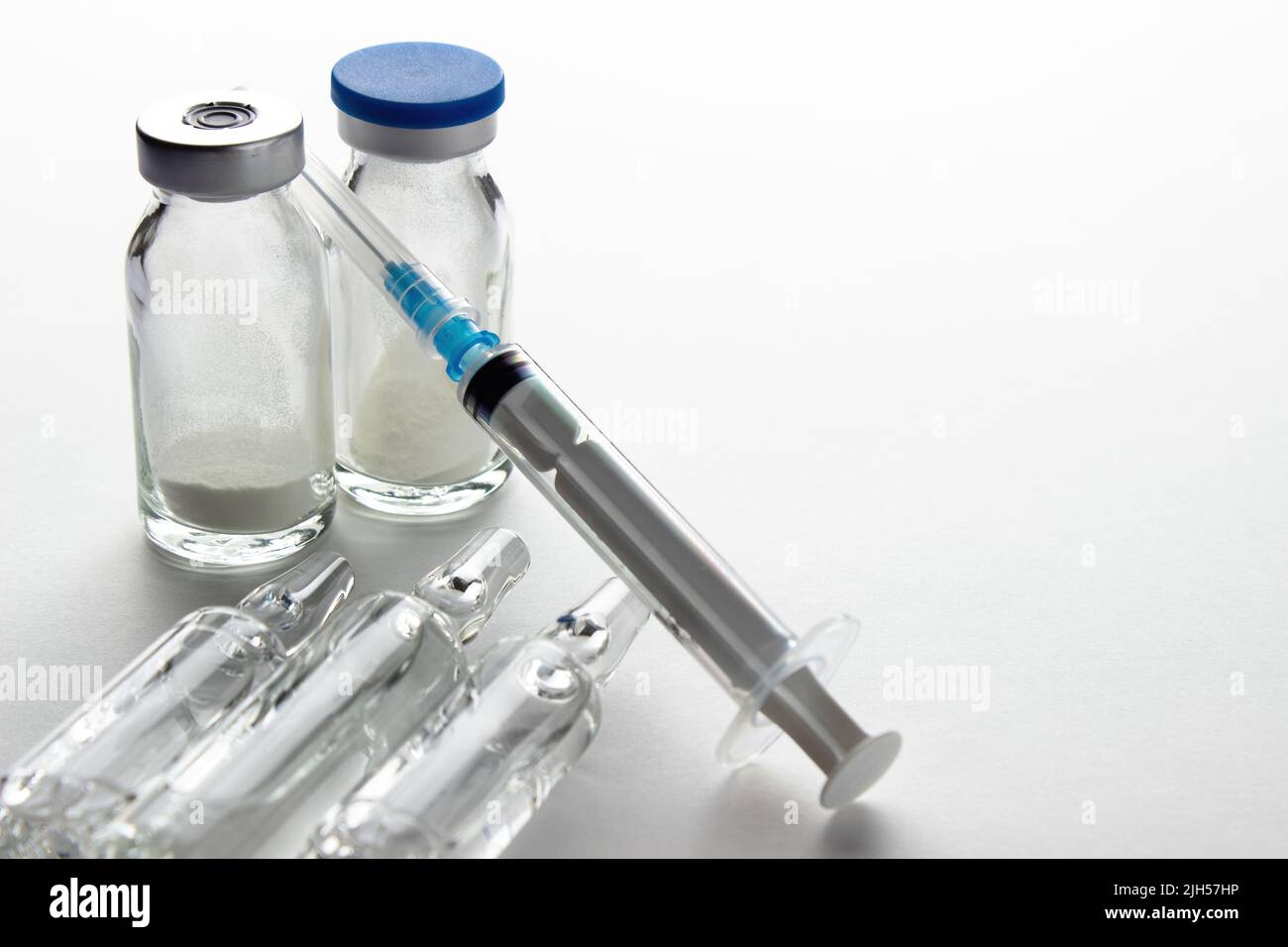 Flacons et seringue sur table lumineuse. Vaccination et immunisation Banque D'Images