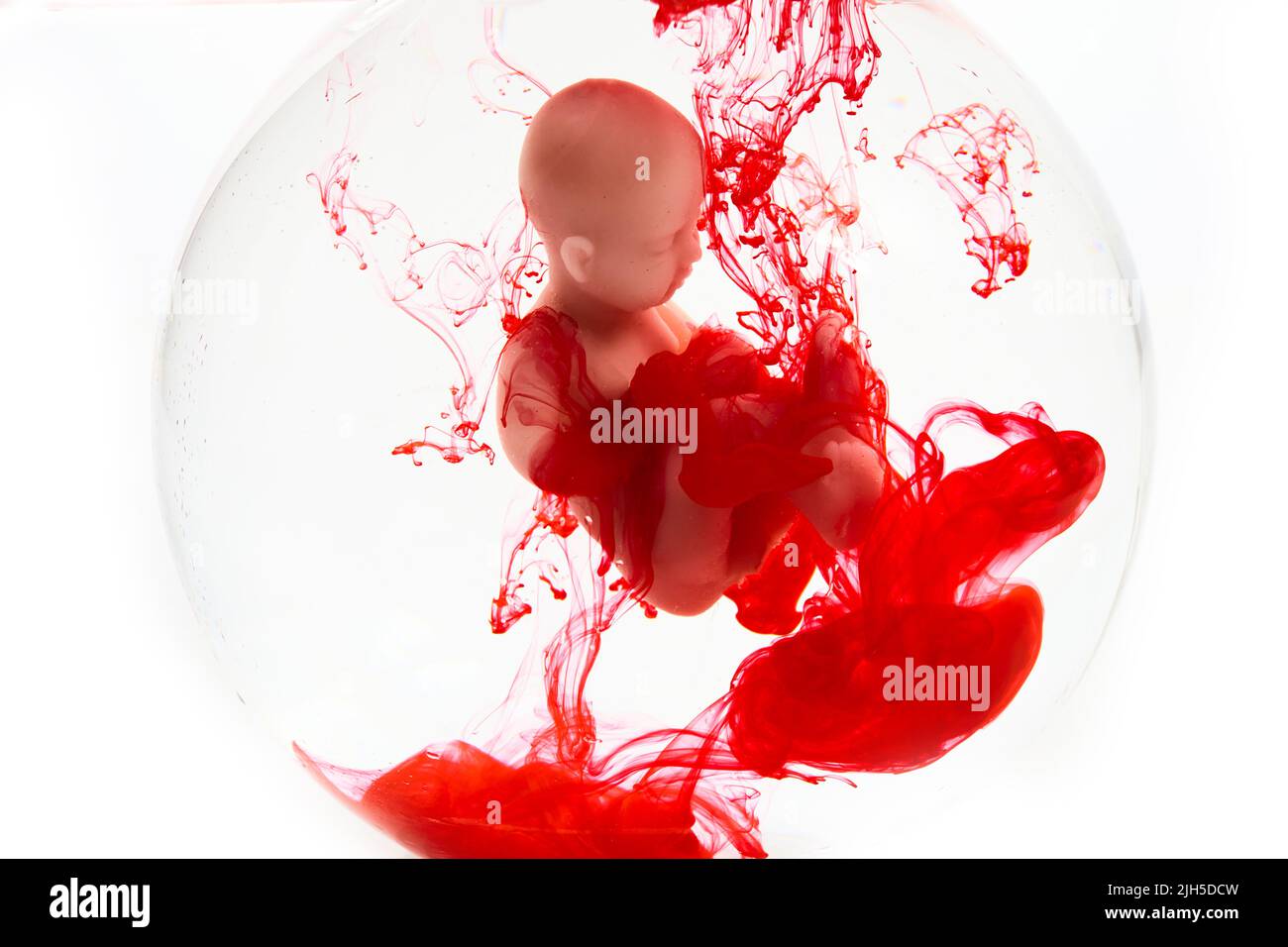 Concept d'avortement. Bébé poupée dans le sang rouge ressemble à l'abortation. Banque D'Images