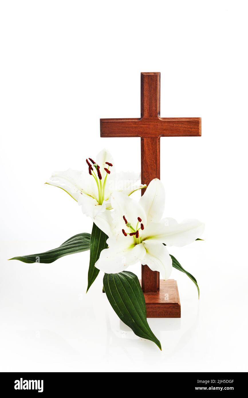 Croix avec des lys isolés sur fond blanc Pâques, carte de baptême. Banque D'Images
