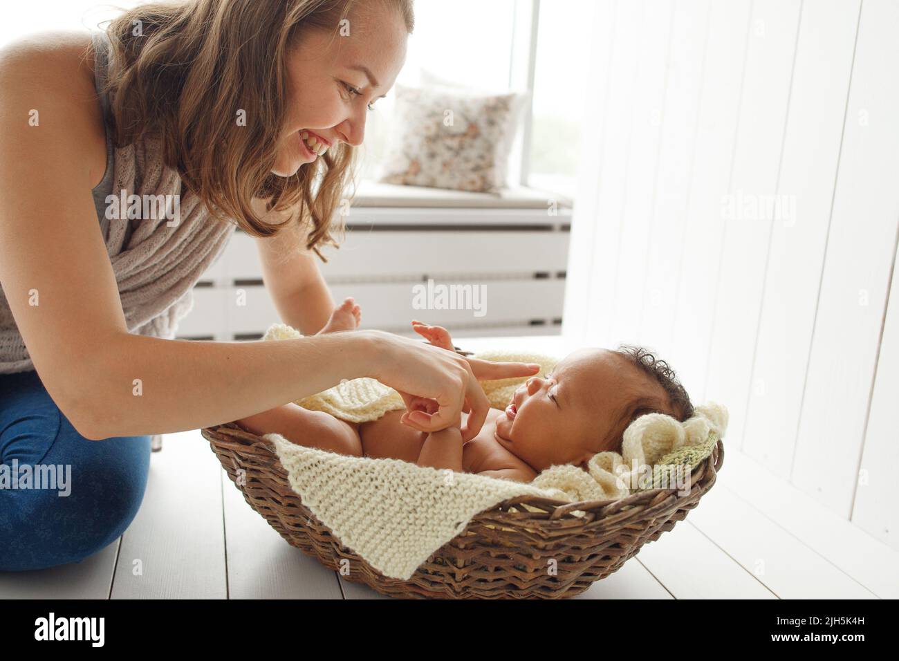 Mère souriante jouant avec bébé nouveau-né, profil Banque D'Images
