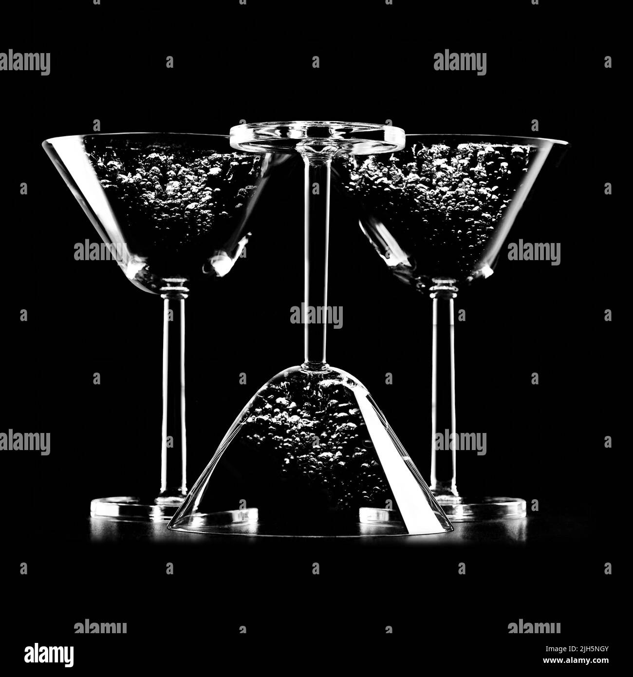 Silhouette de verres à cocktail isolés sur fond noir avec du liquide et des bulles. Image abstraite en noir et blanc avec cocktails Banque D'Images