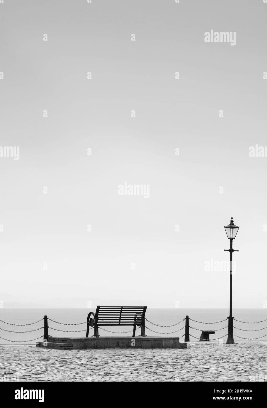 Banc vide solitaire dans un paysage tranquille ouvert par la mer pour la pleine conscience et la méditation Banque D'Images