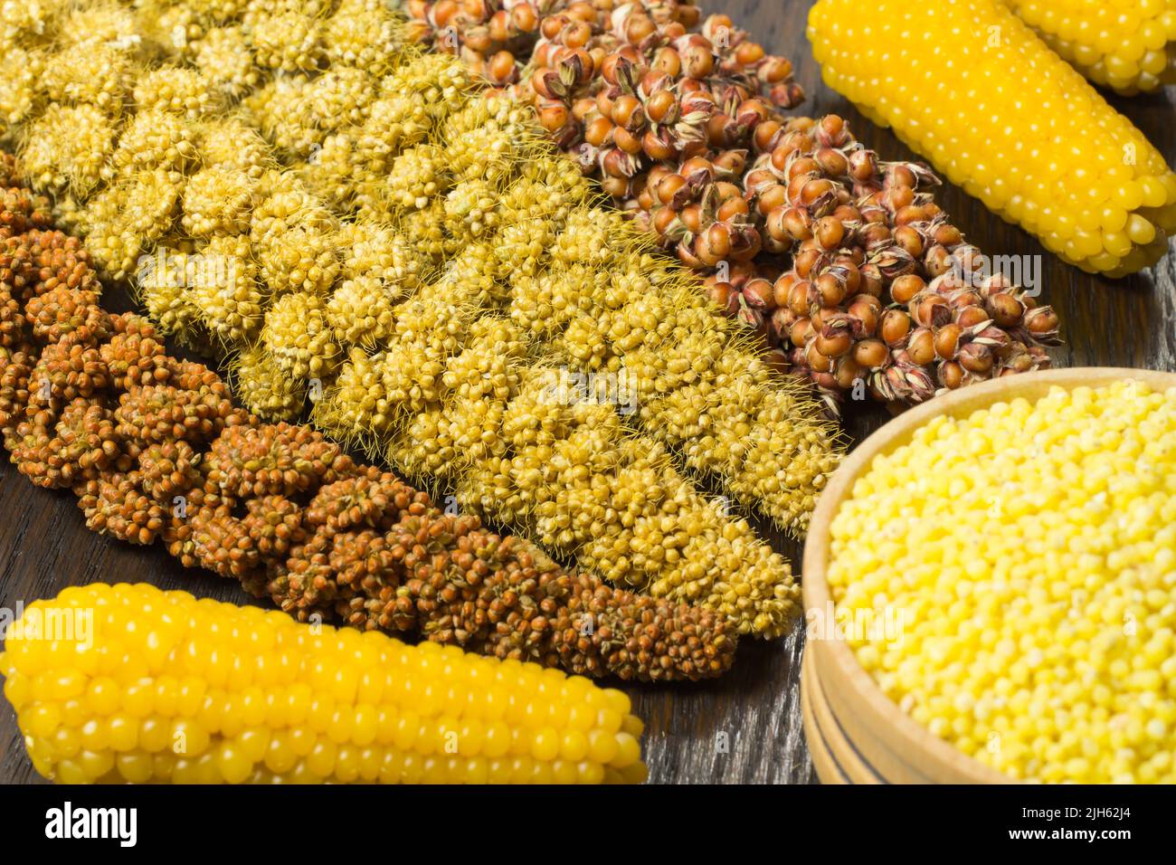 Brindilles de millet rouge et jaune. Grain du millet jaune dans un panier en bois Banque D'Images