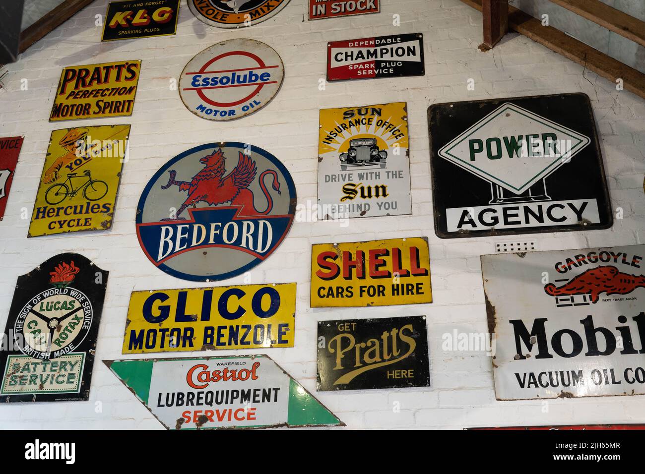 Collection de panneaux publicitaires de moteur vintage affichés sur le mur blanc Banque D'Images