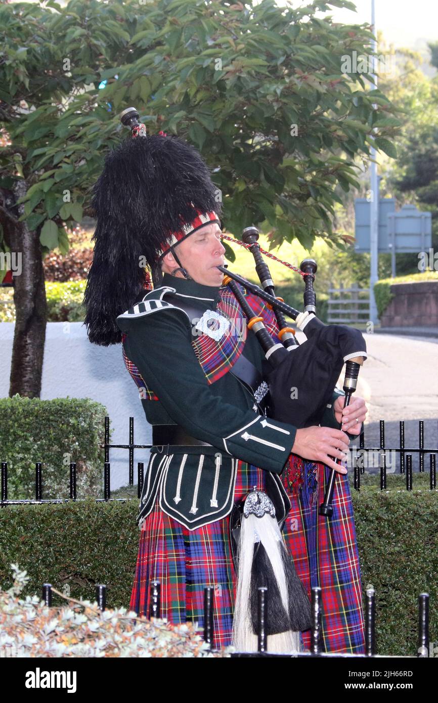 Brig o Doon Hotel, Alloway, Ayrshire, Écosse , Royaume-Uni. Un joueur de cornemuse en robe de haute montagne joue pour les personnes arrivant à l'hôtel en soirée d'été Banque D'Images