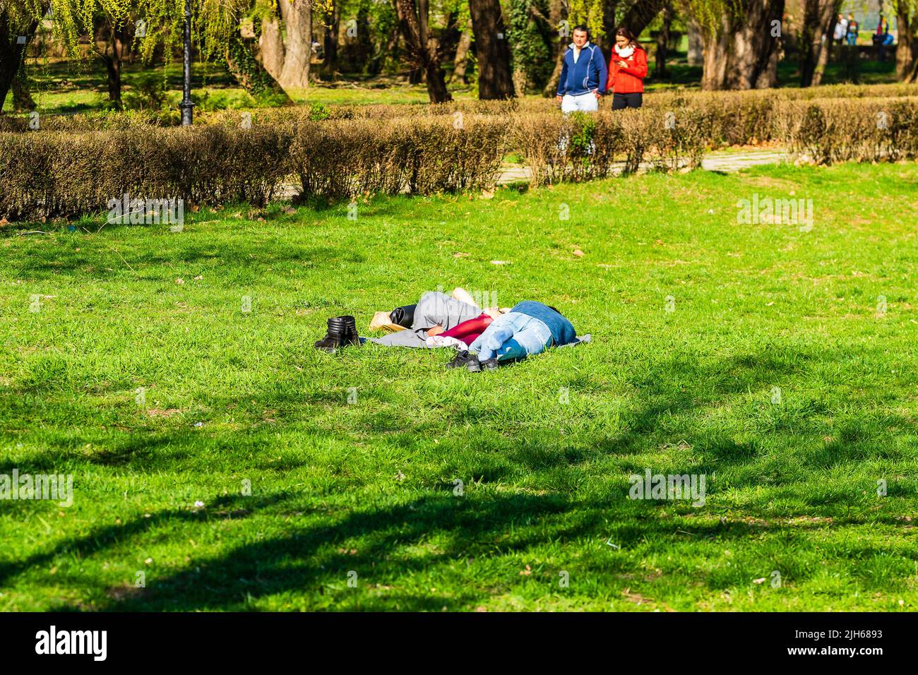 Targoviste, Roumanie - 2019. Groupe de personnes sur l'herbe dans le parc central. Banque D'Images