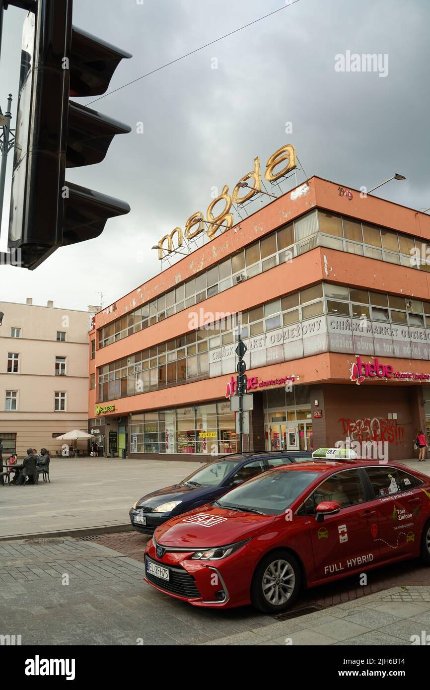 Lodz, Pologne - 08 juillet 2022: Arrêt de voiture hybride devant un feu de rue contre le bâtiment dans la célèbre rue piotrkowska dans le centre-ville Banque D'Images