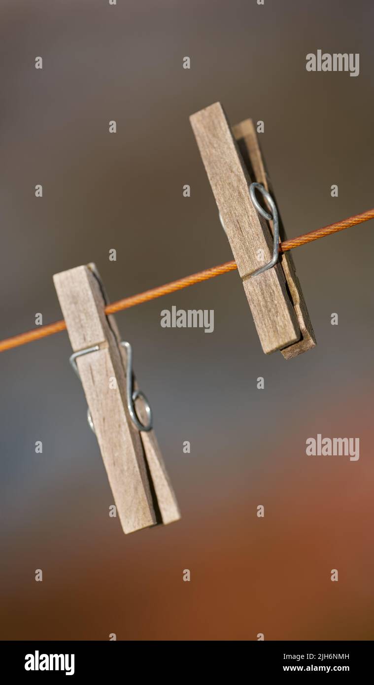 Gros plan de deux pinces à vêtements sur une ligne de lavage à l'extérieur sur un arrière-plan flou. Épingles à linge en bois utilisées pour fixer et suspendre le linge propre au soleil Banque D'Images