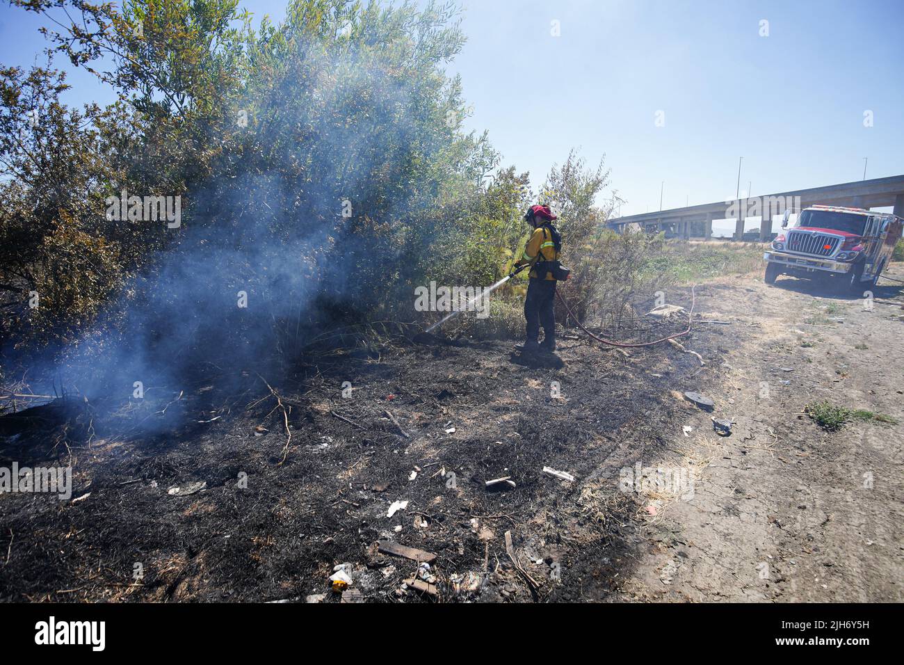 Richmond, États-Unis. 15th juillet 2022. Un pompier utilise de l'eau pour éteindre le feu de broussailles à Richmond. Les pompiers répondent à un incendie de brosse à Richmond, le feu de brosse a commencé vers 1 h 22 et a été contenu par 2 h. la cause de l'incendie est la combustion ouverte de déchets dans la région. Crédit : SOPA Images Limited/Alamy Live News Banque D'Images