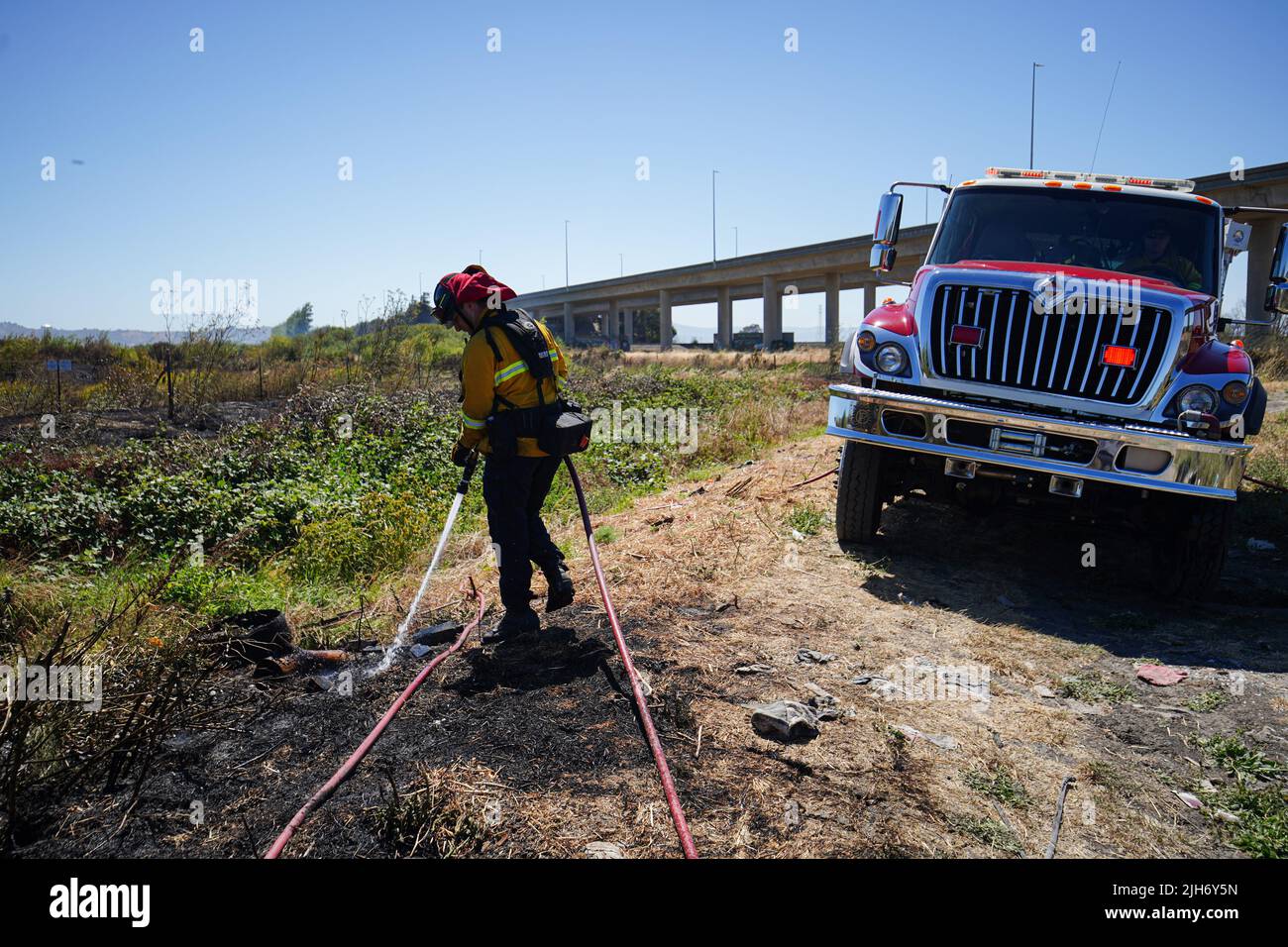 Richmond, États-Unis. 15th juillet 2022. Un pompier utilise de l'eau pour éteindre le feu de broussailles à Richmond. Les pompiers répondent à un incendie de brosse à Richmond, le feu de brosse a commencé vers 1 h 22 et a été contenu par 2 h. la cause de l'incendie est la combustion ouverte de déchets dans la région. Crédit : SOPA Images Limited/Alamy Live News Banque D'Images