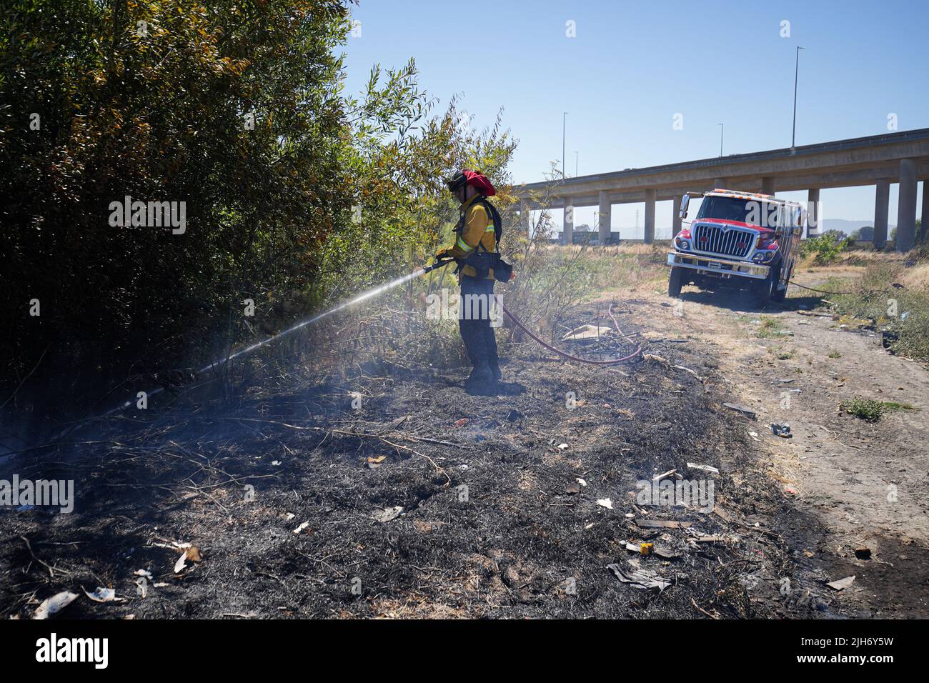 Richmond, États-Unis. 15th juillet 2022. Un pompier utilise de l'eau pour éteindre le feu de broussailles à Richmond. Les pompiers répondent à un incendie de brosse à Richmond, le feu de brosse a commencé vers 1 h 22 et a été contenu par 2 h. la cause de l'incendie est la combustion ouverte de déchets dans la région. Crédit : SOPA Images Limited/Alamy Live News Banque D'Images