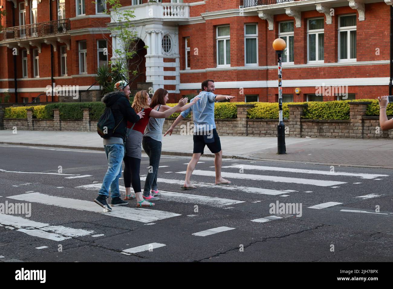 LONDRES, GRANDE-BRETAGNE - 17 MAI 2014 : quatre jeunes non identifiés traversent Abbey Road sur le célèbre croisement, sur lequel la photo la plus célèbre de l'être Banque D'Images