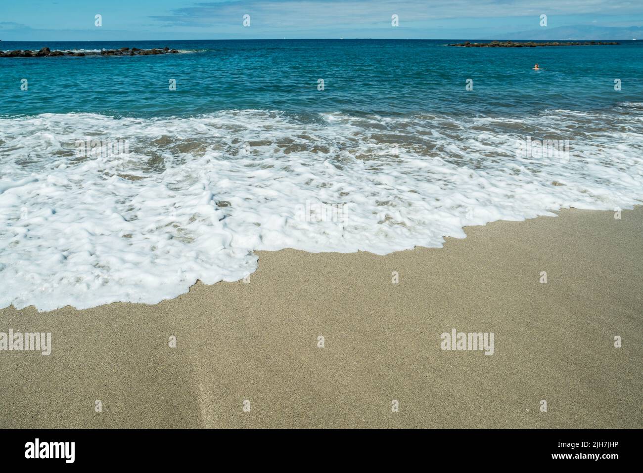 Mousse d'océan couvrant belle longue plage de sable. Banque D'Images