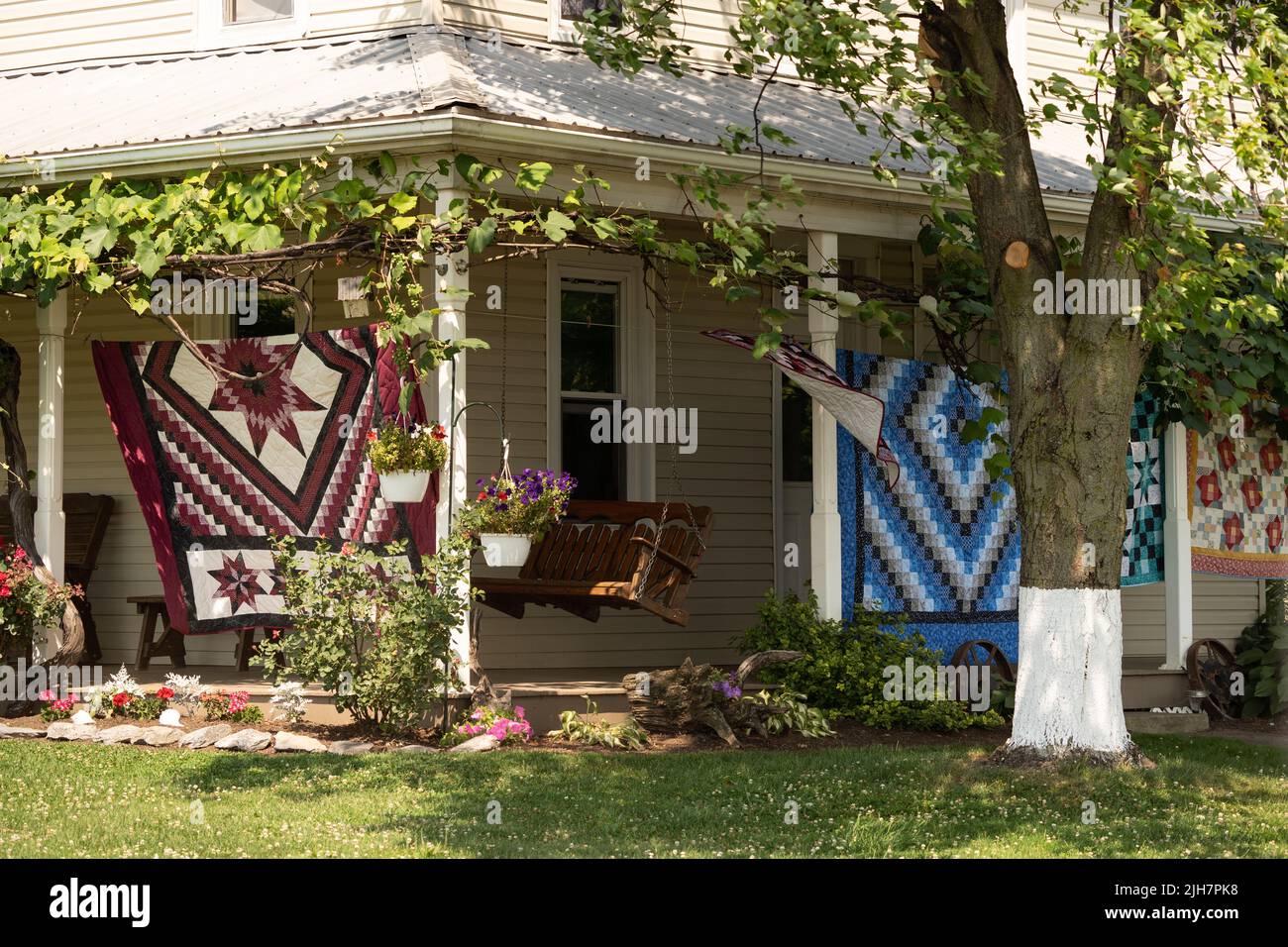 Ephrata, Pennsylvanie: 1 juillet 2022: Belles courtepointes faites à la main exposées sur le porche avant à vendre sur la ferme Amish. Banque D'Images