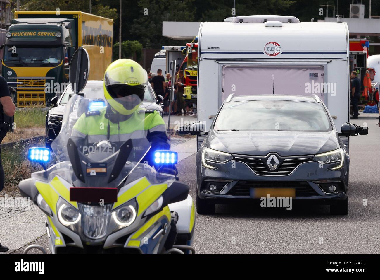 Ratingen, Allemagne. 16th juillet 2022. Un motocycliste de police guide une voiture avec une caravane à l'extérieur de l'autoroute A3 près de Ratingen et sur la zone de service de Hösel. La police utilise le point de mi-parcours des vacances d'été comme une opportunité pour les contrôles de circulation à l'échelle nationale. Credit: David Young/dpa - ATTENTION: Les plaques d'immatriculation ont été pixélisées pour des raisons juridiques/dpa/Alamy Live News Banque D'Images