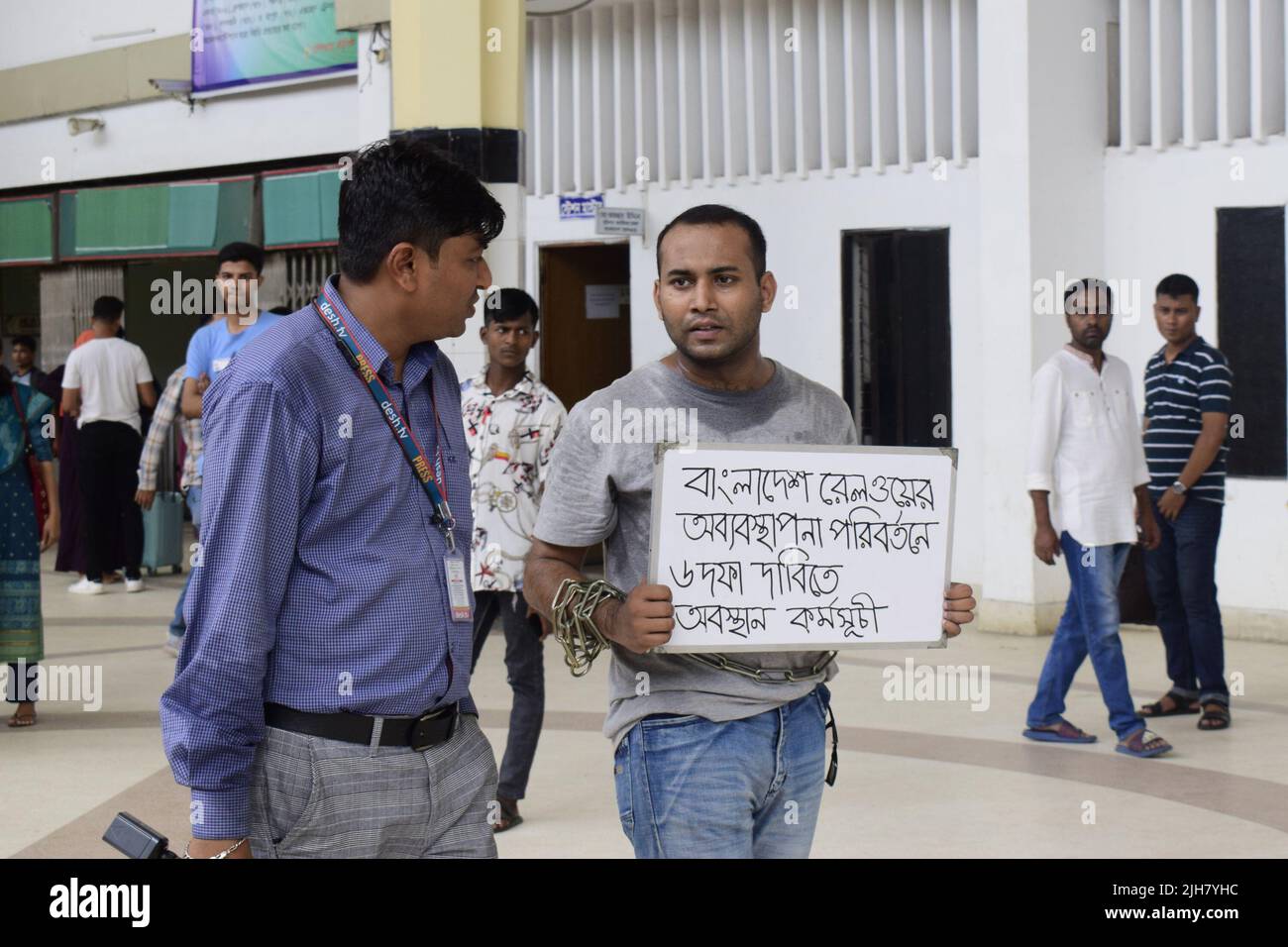 Mohiuddin Roni, étudiant à l'Université de Dhaka, a séjourné à la gare de Kamalapur, Dhaka pendant 10 jours pour protester contre la commercialisation noire des billets de train et contre la mauvaise gestion globale. Pendant Eid UL-Adha, sur son retour à la maison, il a réservé le billet de train en ligne mais n'a pas pu voyager en raison du marché noir avec le billet. Il a ensuite pris une position de protestation à la gare et a commencé à protester par des arts de la scène. Il lui-même a enchaîné ses mains. Il a présenté des demandes en 6 points et a annoncé de poursuivre son programme de sit-in jusqu'à ce que ces demandes soient acceptées. Déjà les photos et la vidéo Banque D'Images