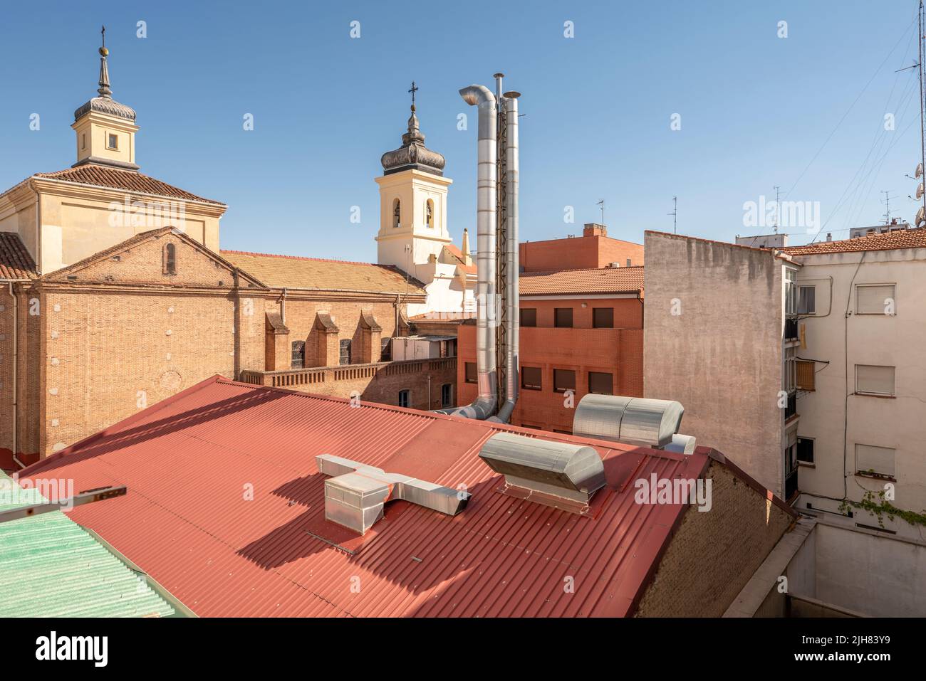 Vue sur une cour intérieure d'un bloc avec les plafonds d'une nef avec fumée et les tours d'une église avec cloches Banque D'Images