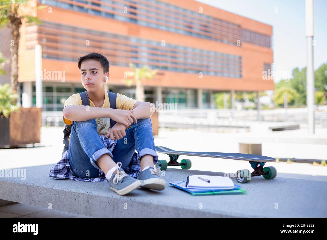 Adolescent étudiant garçon à l'écoute de la musique à l'extérieur. Espace pour le texte. Banque D'Images