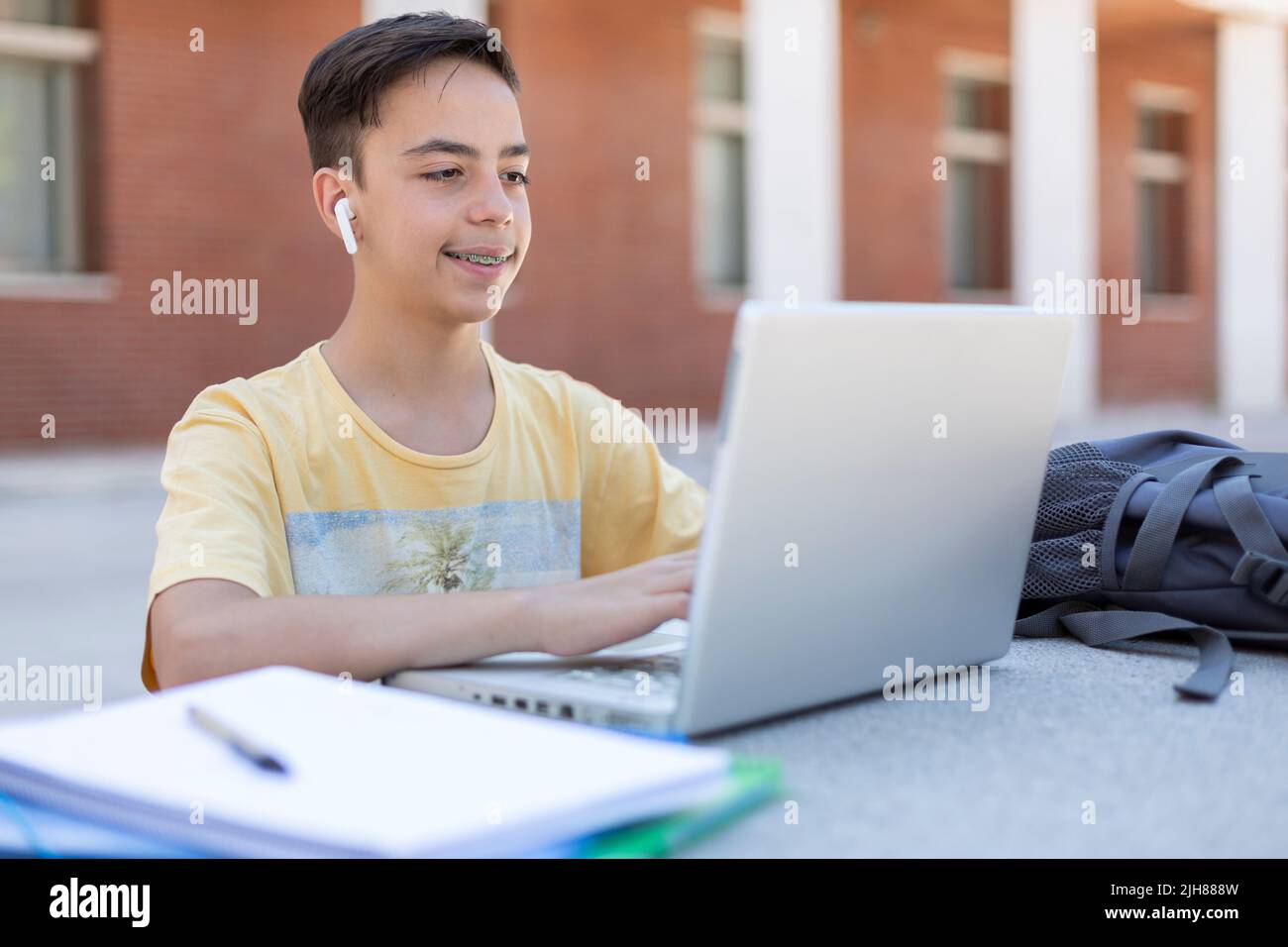 Étudiant de lycée de race blanche travaillant avec un ordinateur portable à l'extérieur. Enseignement secondaire. Banque D'Images