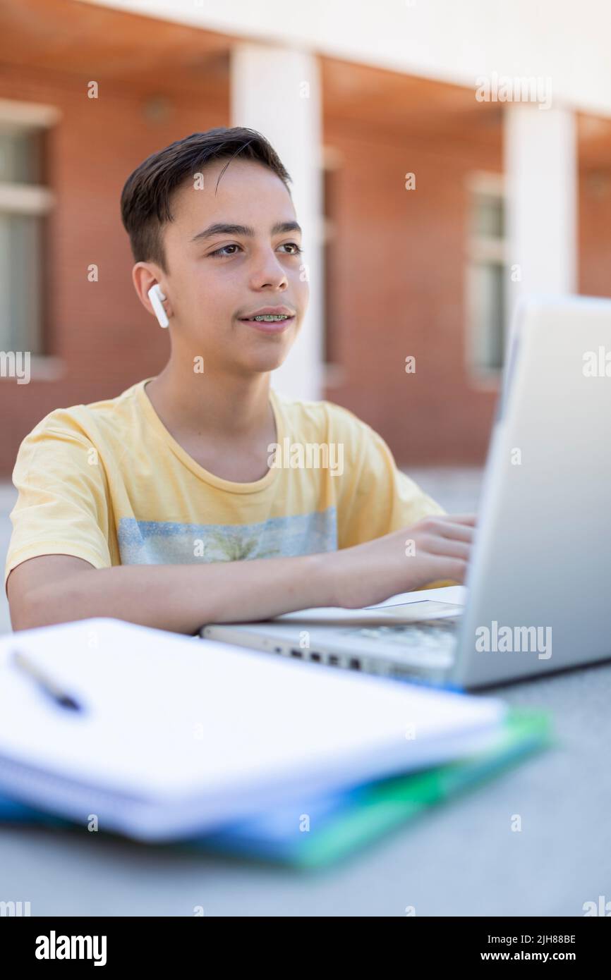 Adolescent de race blanche étudiant à l'extérieur. Enseignement secondaire. Banque D'Images