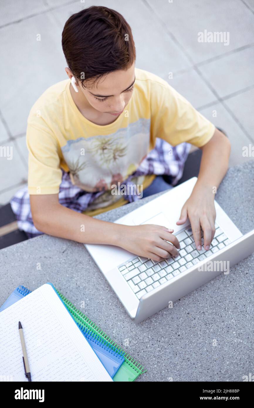 Vue de dessus d'un adolescent à l'aide d'un ordinateur portable. Élève du secondaire. Banque D'Images