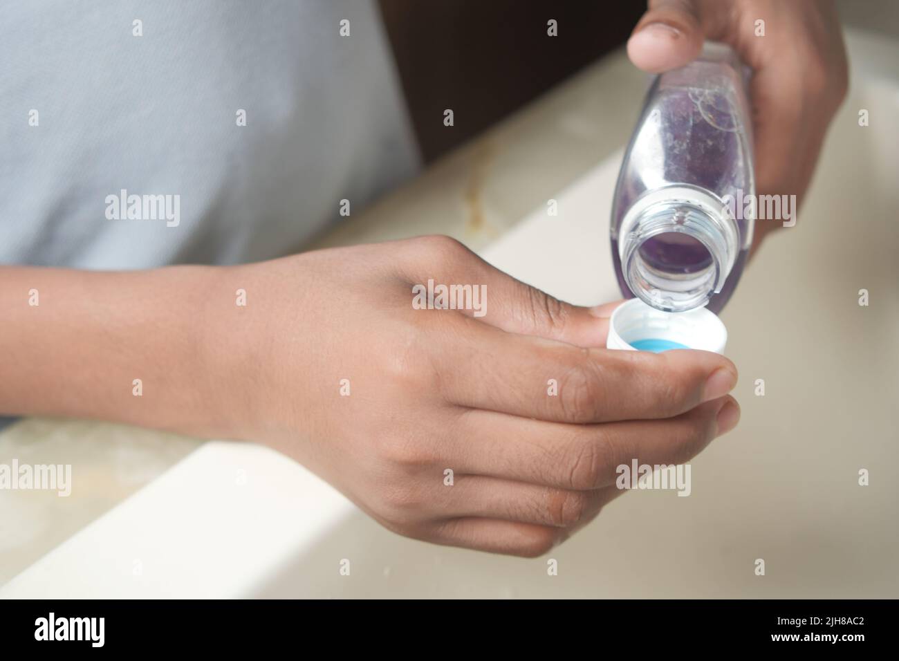 liquide de bain de bouche s'écoulant dans un bouchon Banque D'Images