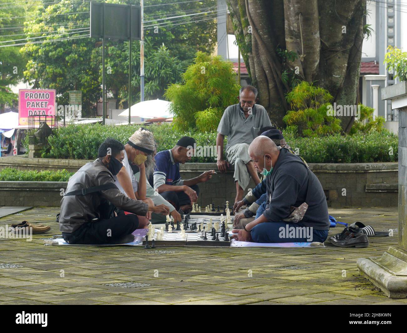 certaines personnes semblent jouer sérieusement aux échecs dans le parc. Banque D'Images