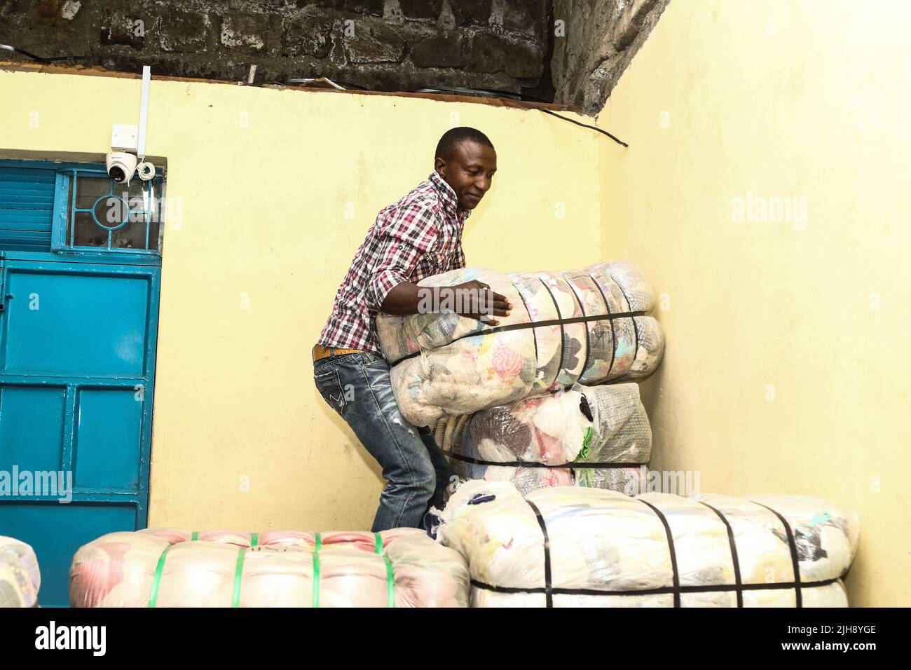 Un travailleur est vu arranger des balles de vêtements d'occasion dans un entrepôt. La mode rapide est responsable de l'accumulation accrue de déchets textiles dans les décharges de déchets dans la plupart des pays du sud où des vêtements d'occasion de mauvaise qualité sont expédiés quotidiennement. Maintenant, il y a des appels à éliminer ces vêtements pour protéger l'environnement. Raila Odinga, candidate à la coalition politique kényane, lors du lancement du manifeste de son parti, sur 6 juin 2022, a déclaré que l'importation de vêtements d'occasion était responsable de la destruction de l'industrie textile au Kenya Banque D'Images