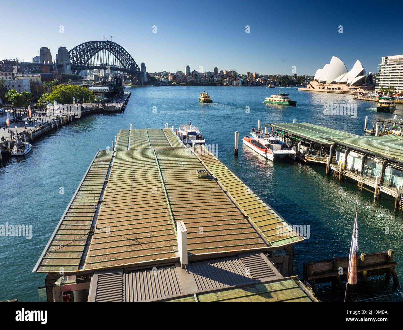 Le Circular Quay compte les quais 6 et 5 sur Sydney Cove, avec des ferries pour le port, le Harbour Bridge et l'opéra en arrière-plan. Banque D'Images